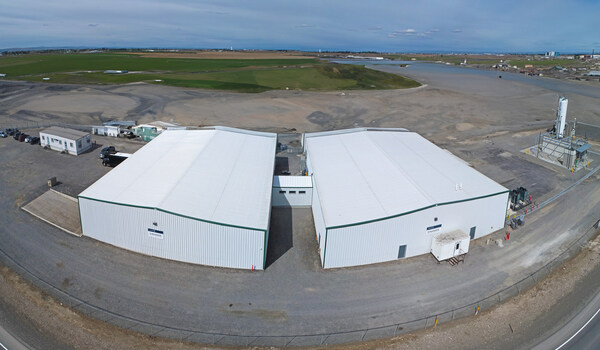 battery material manufacturing plant aerial shot of white building with blue sky